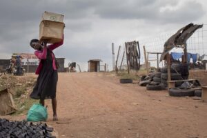 A-lady-walks-to-the-street-to-set-up-her-stall-on-a-cloudy-day-in-kalerweKampalaUganda