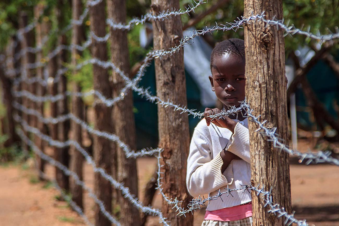 A-refugee-child-in-bidibidi-refugee-camp-stands-at-a-barbed-wire-child-protection-in-yumbe-uganda