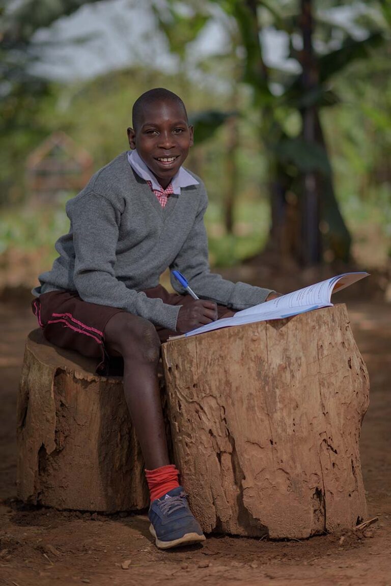A-students-reads-his-books-under-a-tree-shade-in-a-remote-village-in-wakisoUganda-showing-the-extent-to-which-children-acess-quality-education-in-Uganda