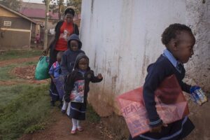 Annet-arrives-at-school-in-the-mornign-with-some-children-whom-she-escorts-to-school-from-the-neighbourhood-in-KampalaUganda