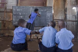 Annet-teaches-a-group-of-pupils-inside-an-iron-sheet-church-in-kalerweUganda