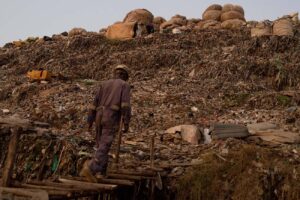 Gabbage-collector-walks-to-a-landfill-to-find-tin-to-recycle-in-kiteezi-Uganda